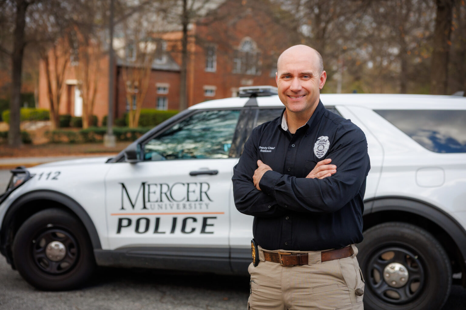 Deputy Chief Robinson standing in front of Mercer Police vehicle.